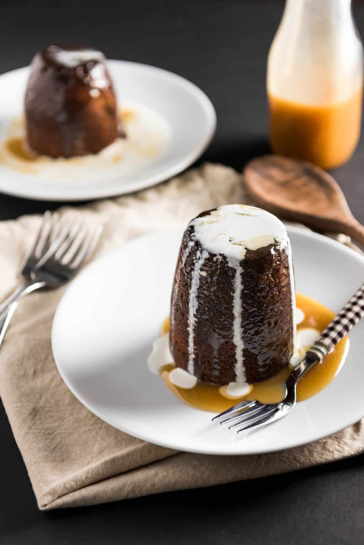 sticky toffee pudding on a white plate with forks