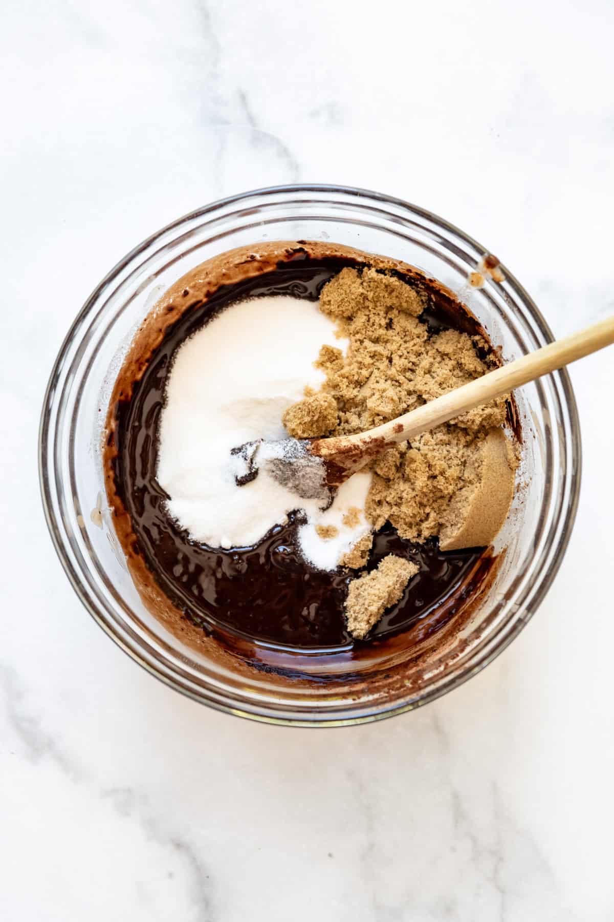 Adding granulated sugar and brown sugar to make brownie batter.