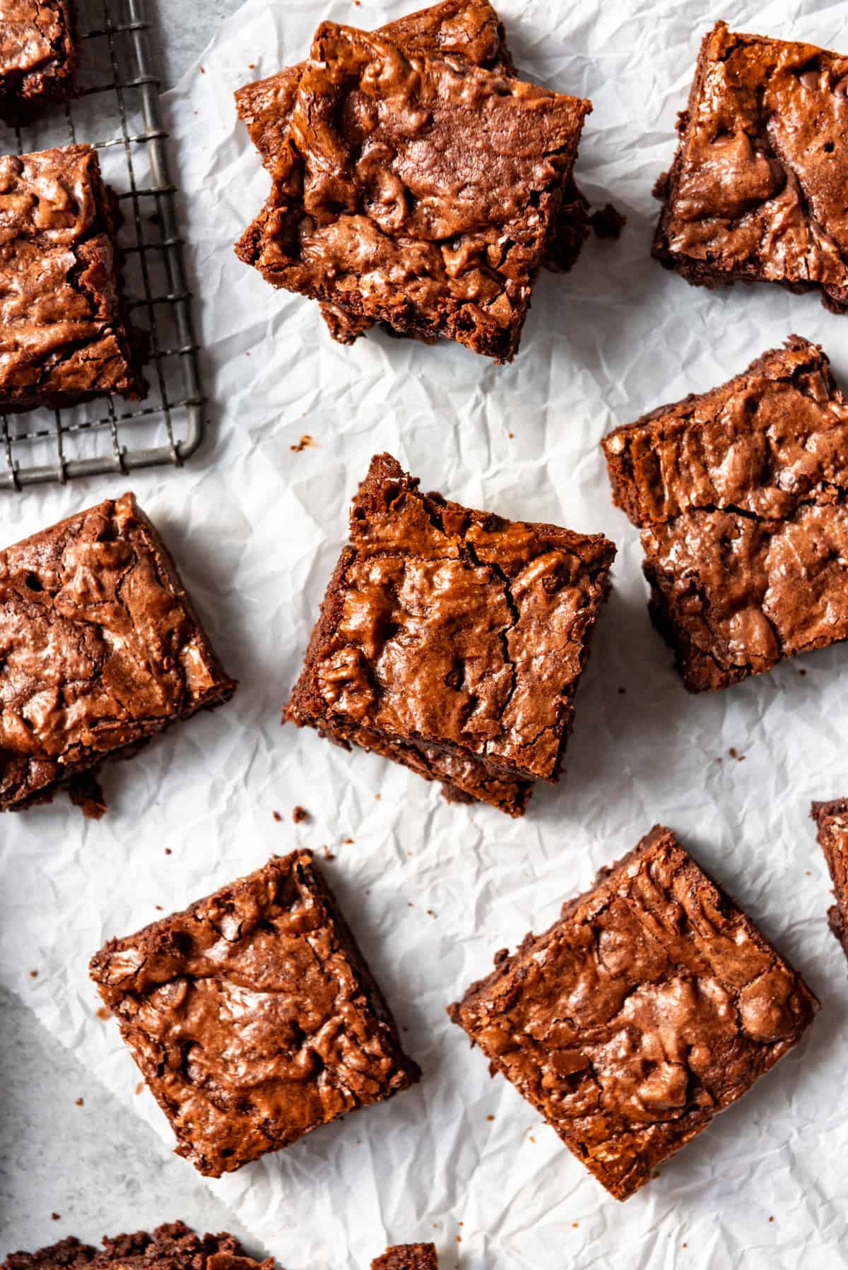 An overhead image of fudgy brownies on white parchment paper.