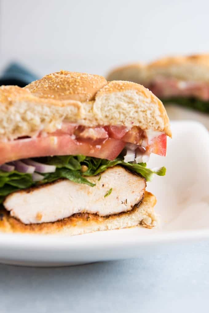 a sliced grilled cajun chicken sandwich showing off the contents inside