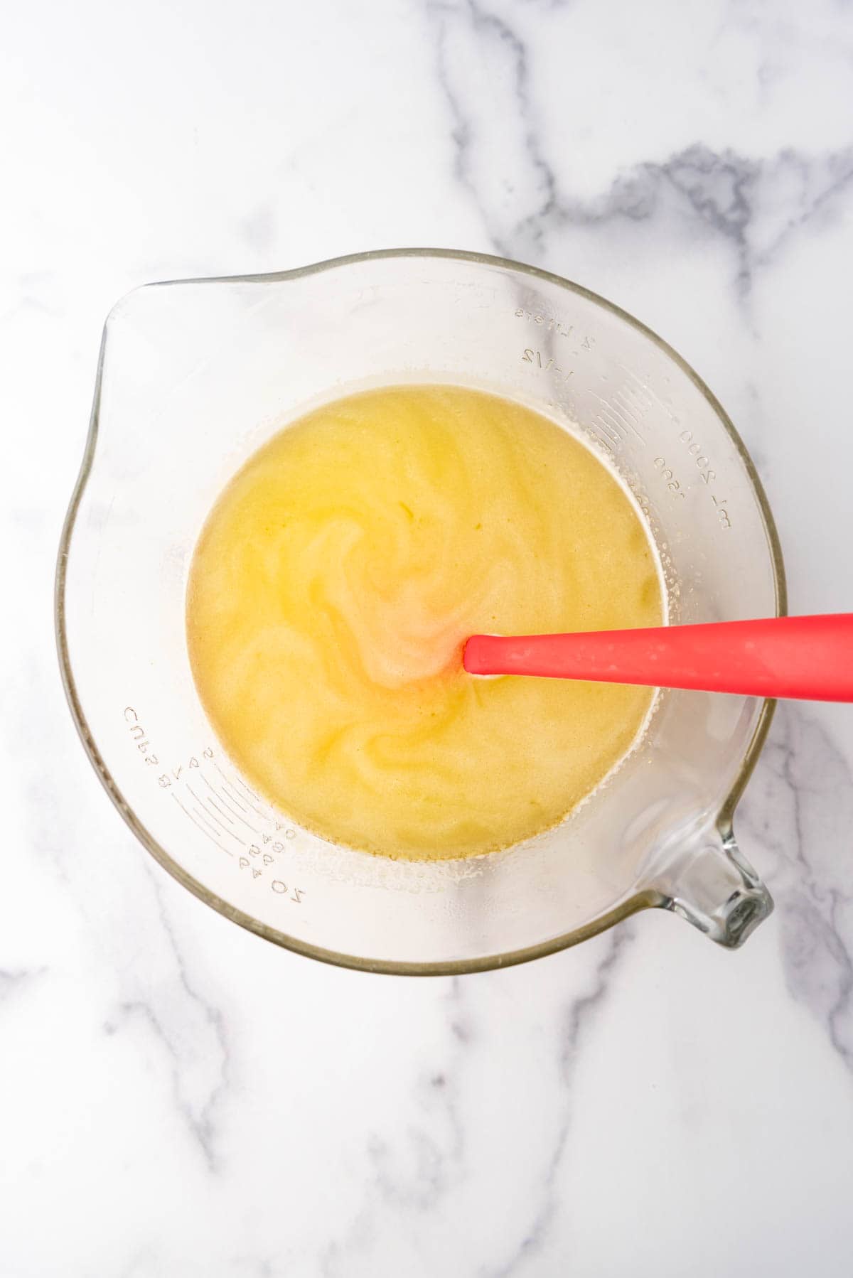 Dissolving lemon jello into hot water.