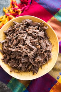 an aerial view of Slow Cooker Mexican Shredded beef in a yellow bowl