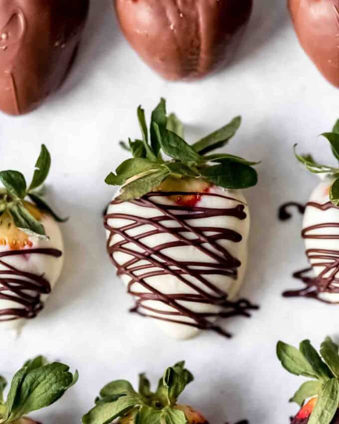 Strawberries covered in white chocolate with a dark chocolate drizzle.