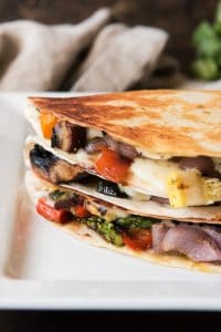 Grilled Summer Vegetable Quesadillas stacked on top of eachother on a white plate
