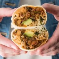 Vegetarian Swiss Chard burrito halves being held in hands