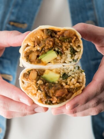 Vegetarian Swiss Chard burrito halves being held in hands