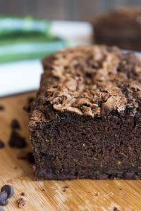a crumb shot of a double chocolate zucchini bread sliced and on a wooden cutting board