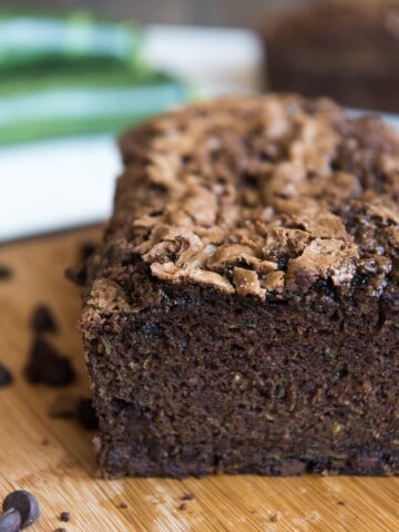 a crumb shot of a double chocolate zucchini bread sliced and on a wooden cutting board