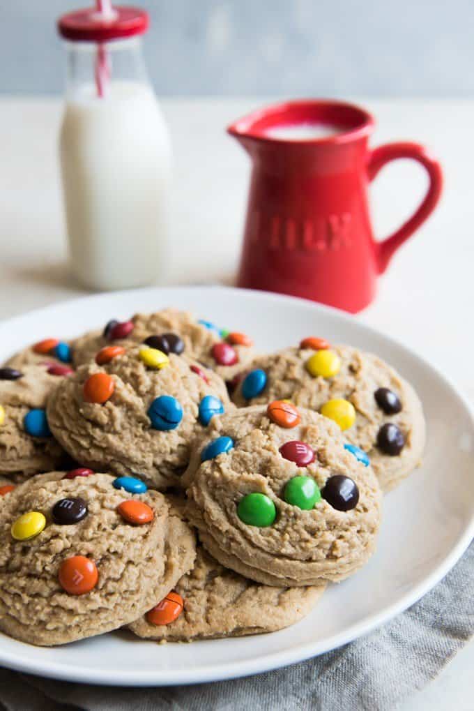 M&M cookies with a red pitcher and bottle of milk in the background