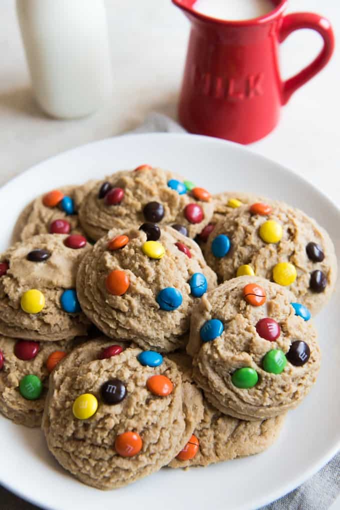 a white plate with a pile of M&M cookies on it