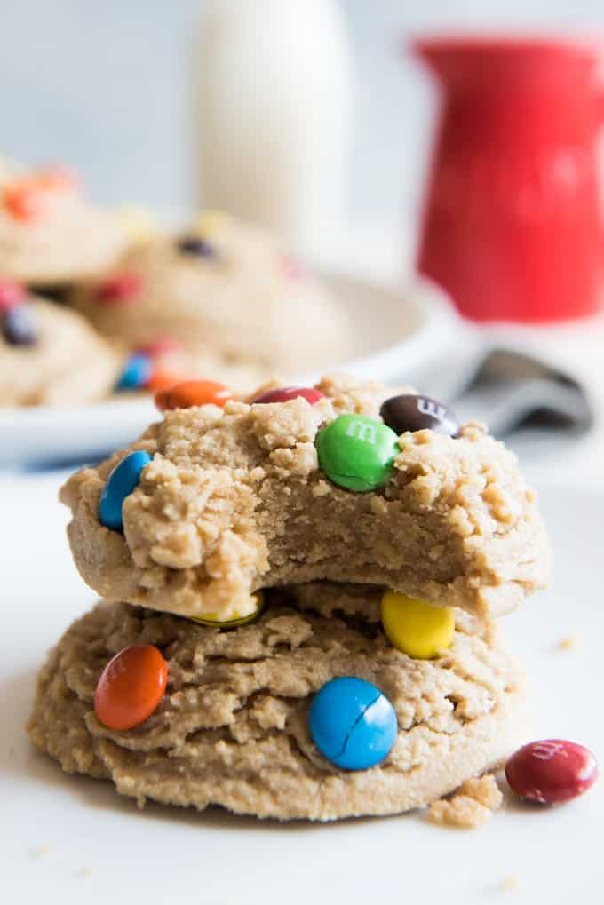 upclose view of soft and big m and m cookies one missing a bite