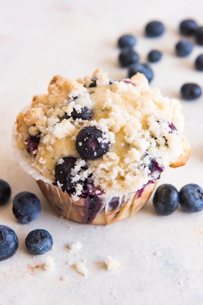 blueberry streusel muffin with fresh blueberries around it