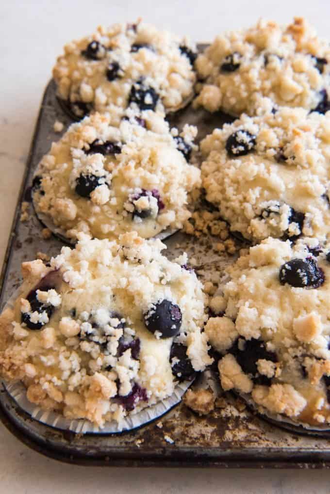a side view of blueberry streusel muffins in a muffin pan