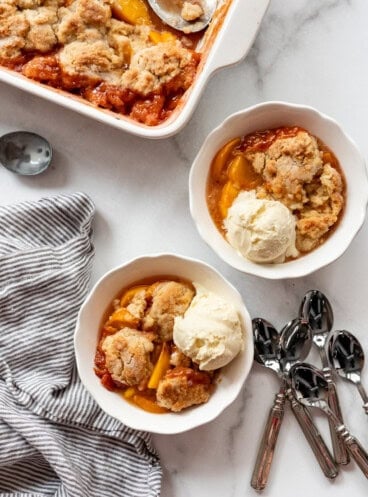 An overhead image of bowls of peach cobbler with ice cream.