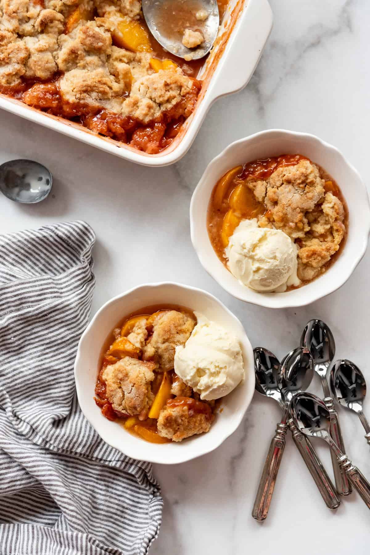 An overhead image of bowls of peach cobbler with ice cream.