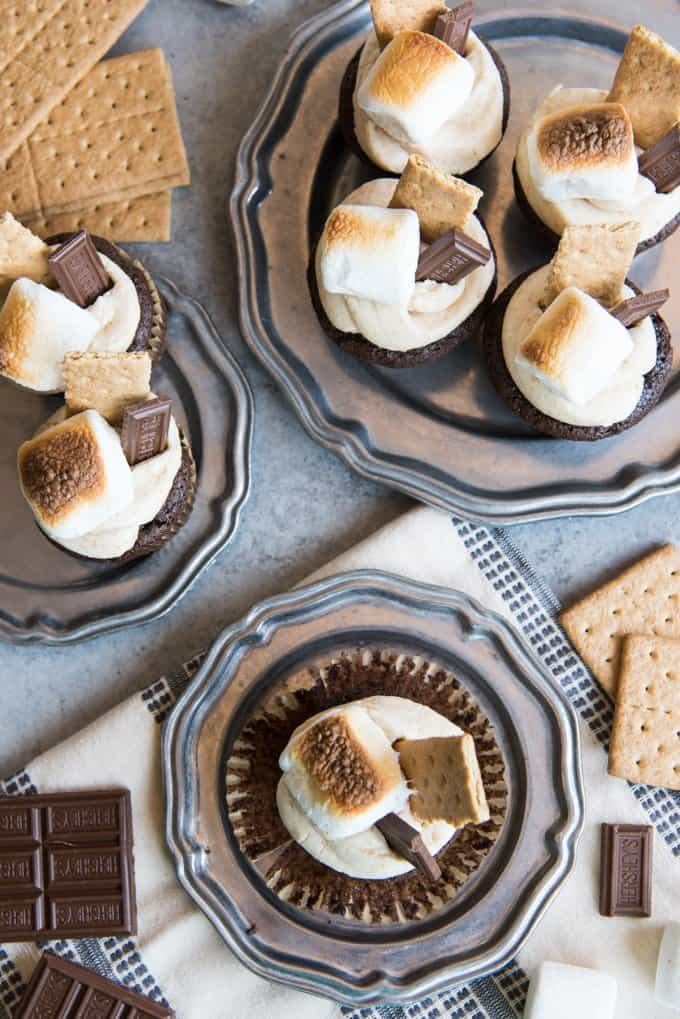 an aerial view of smores cupcakes with graham crackers toasted marshmallows and chocolate bars