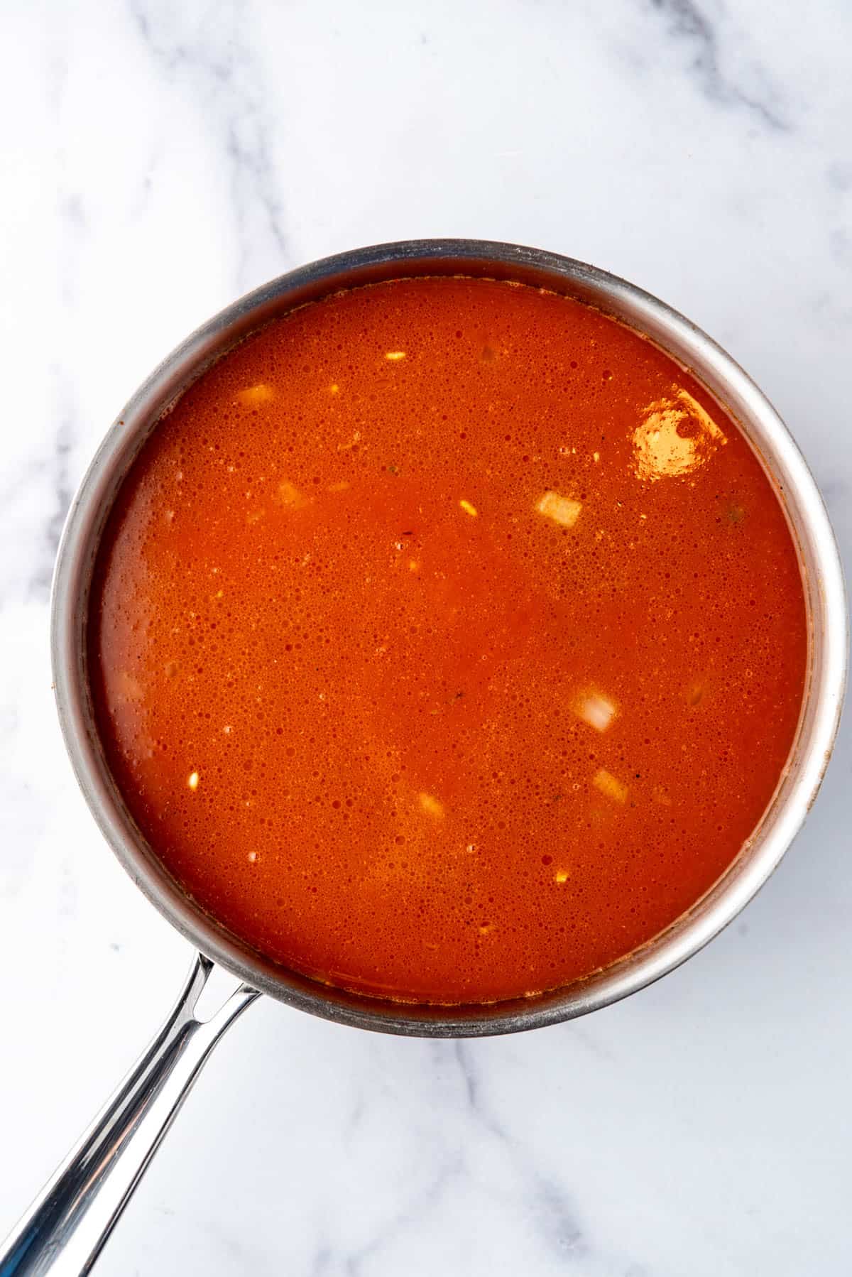 Adding broth to a pan of rice.