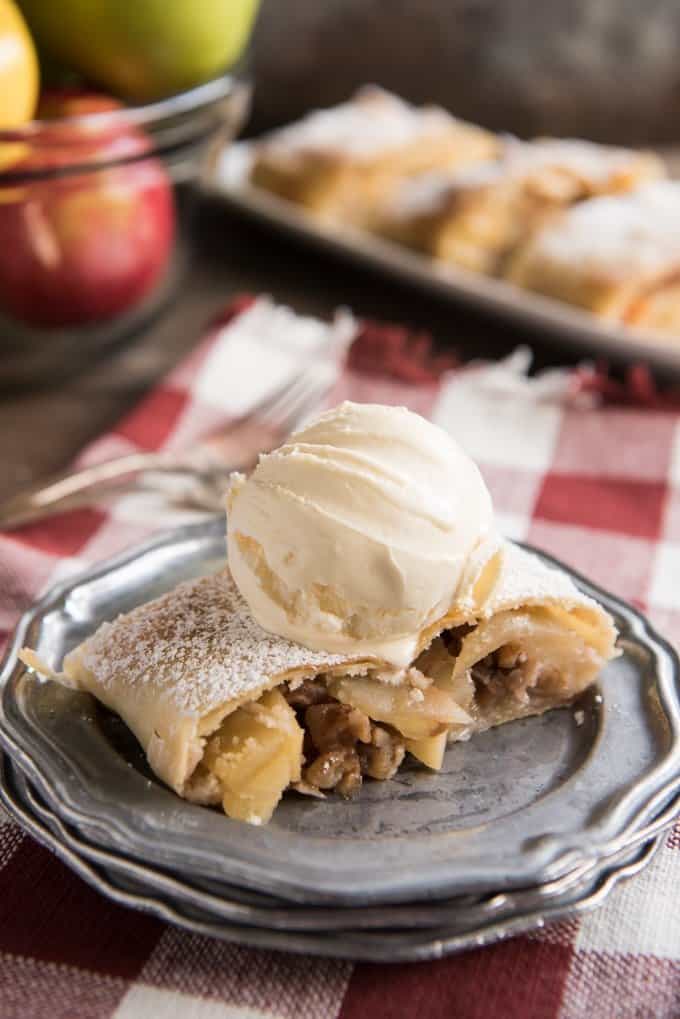 scoop di gelato su strudel di mele su piatto grigio