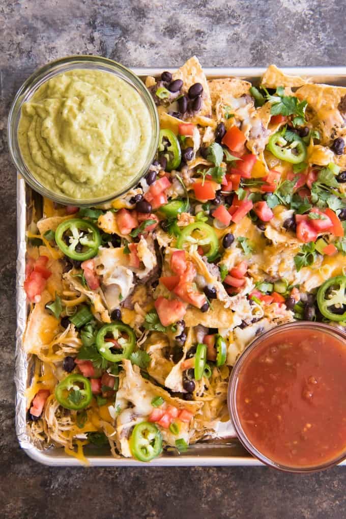 aerial view of gameday sheet pan nachos and two bowls of salsa