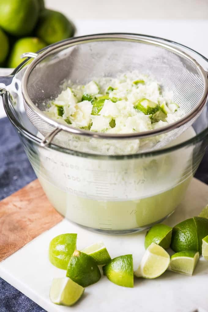 Lime skins and pulp in a strainer after being blended with water and sugar and strained to make Brazilian limeade.