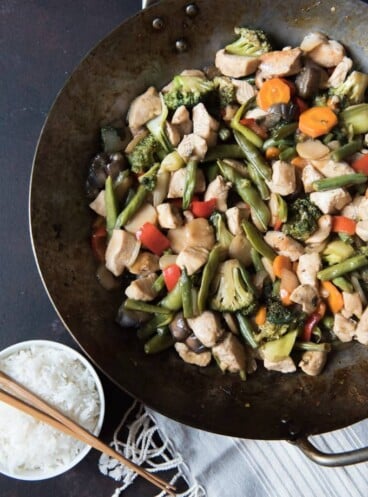 Chicken & Vegetable Stir-Fryin a wok next to a bowl of rice