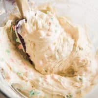 Homemade Rainbow Chip Frosting in a bowl with a spatula