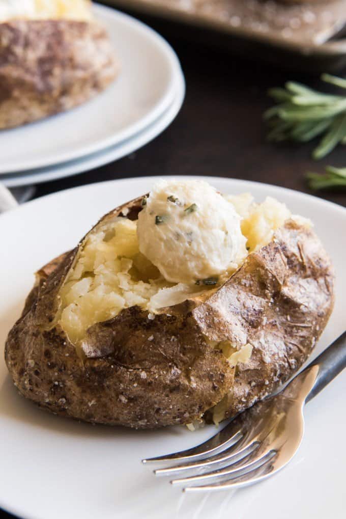 garlic and rosemary butter topped salted baked potato