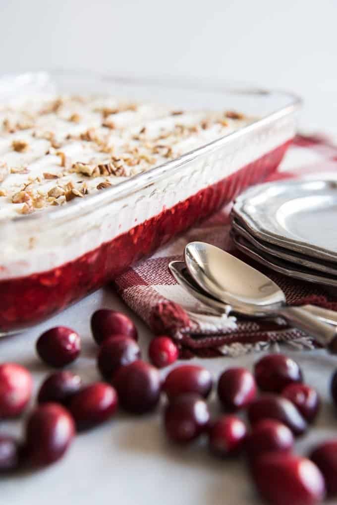 fresh cranberries and cranberry jello salad topped with cream and nuts