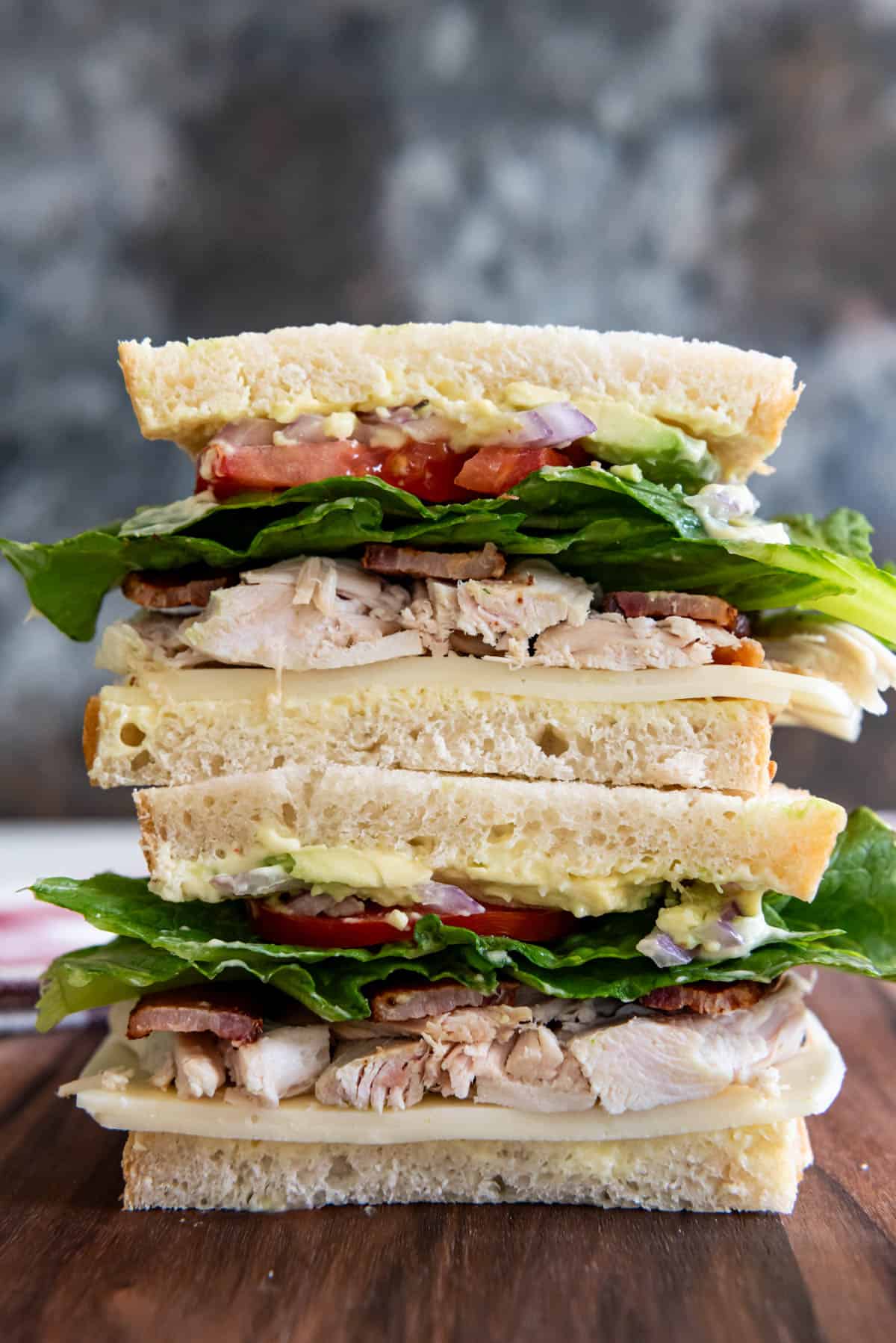 Sliced turkey avocado sandwich stacked on top of each other.