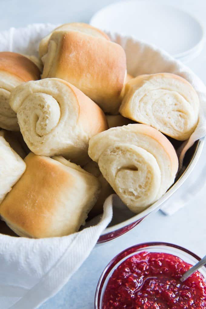 bowl of rolled dinner rolls next to sauce