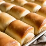 Tray of freshly baked rolls fresh from the oven, with buttered tops.