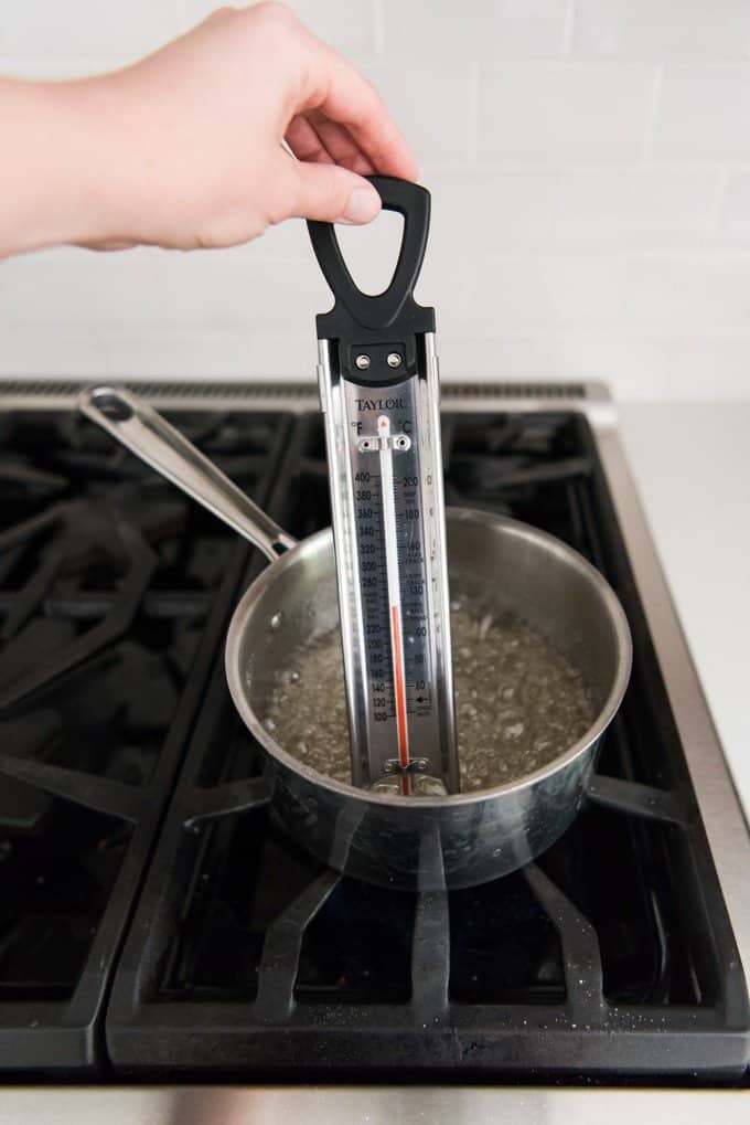 Candy thermometer in a pot of boiling sugar, water and corn syrup for making divinity candy.