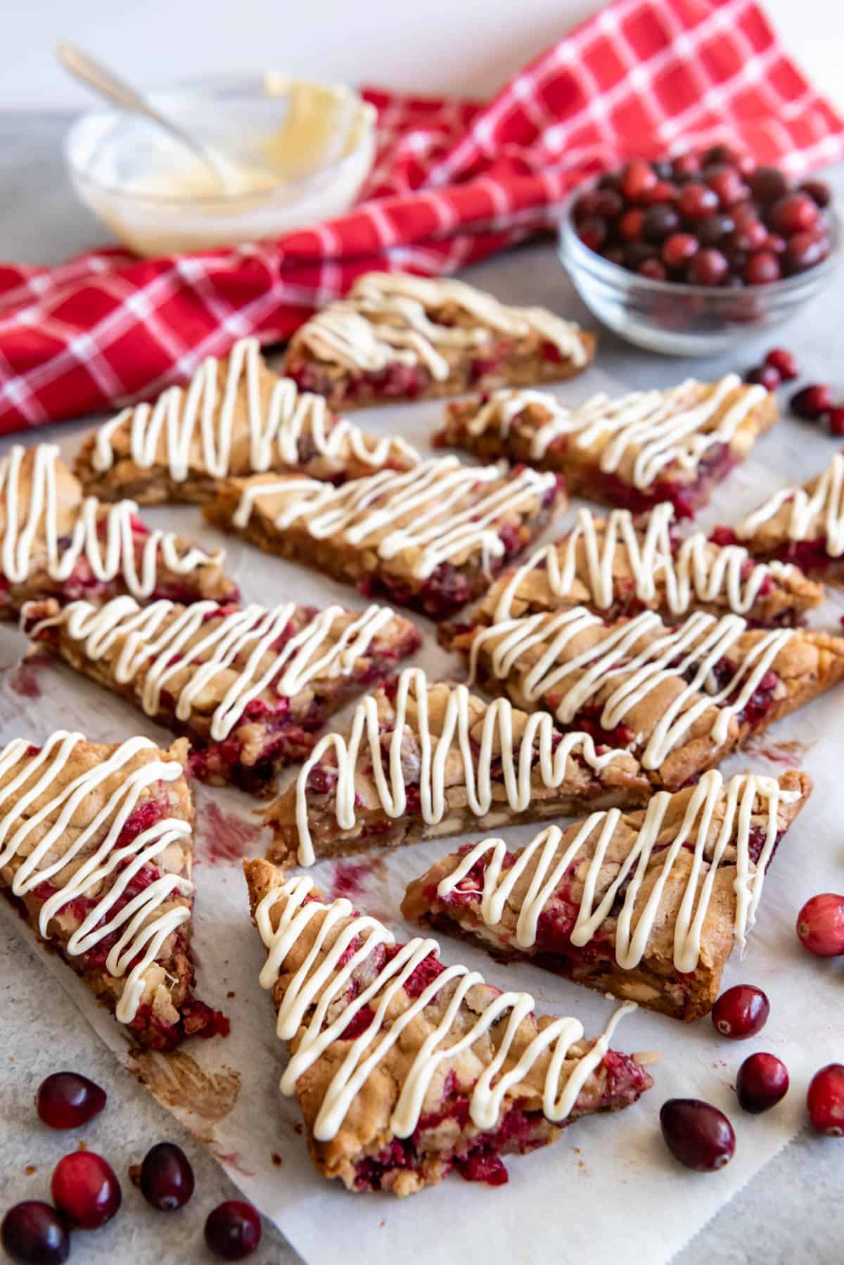Sliced white chocolate cranberry blondies with drizzled icing on top.