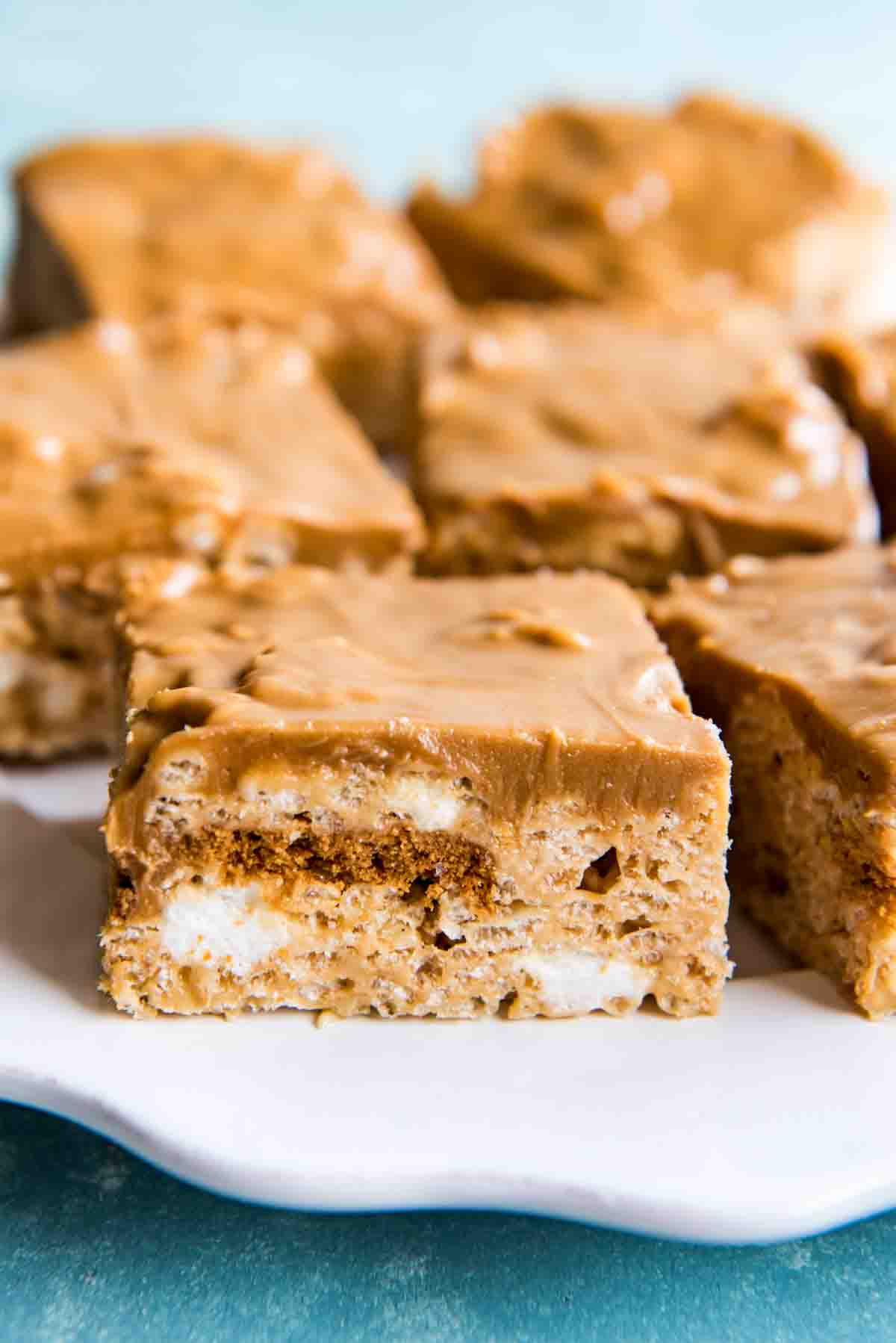 Squares of krispie treats on a white plate.