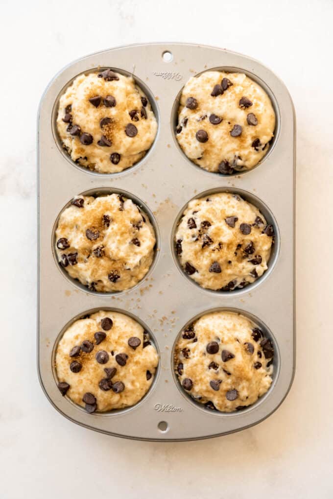 A jumbo muffin pan filled with chocolate chip muffins batter.