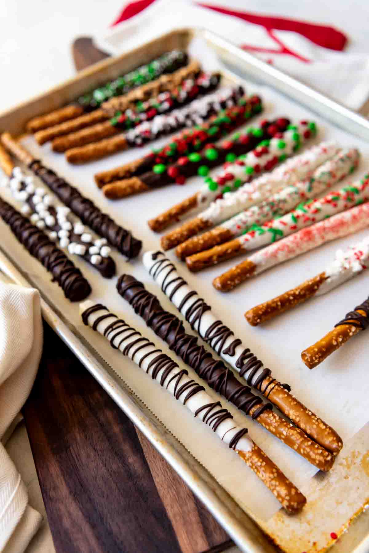 Chocolate covered pretzels decorated and on a baking sheet.