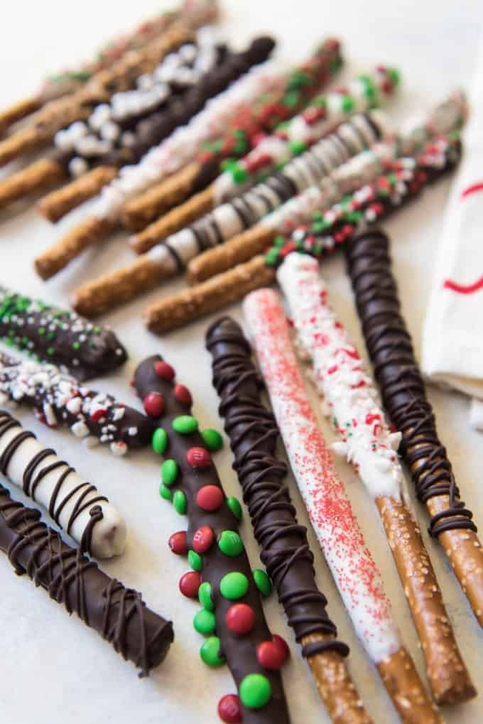 Christmas chocolate covered pretzel rods dipped in both semisweet and white chocolate, then covered with mini M&M's, sprinkles. and crushed candy cane bits!