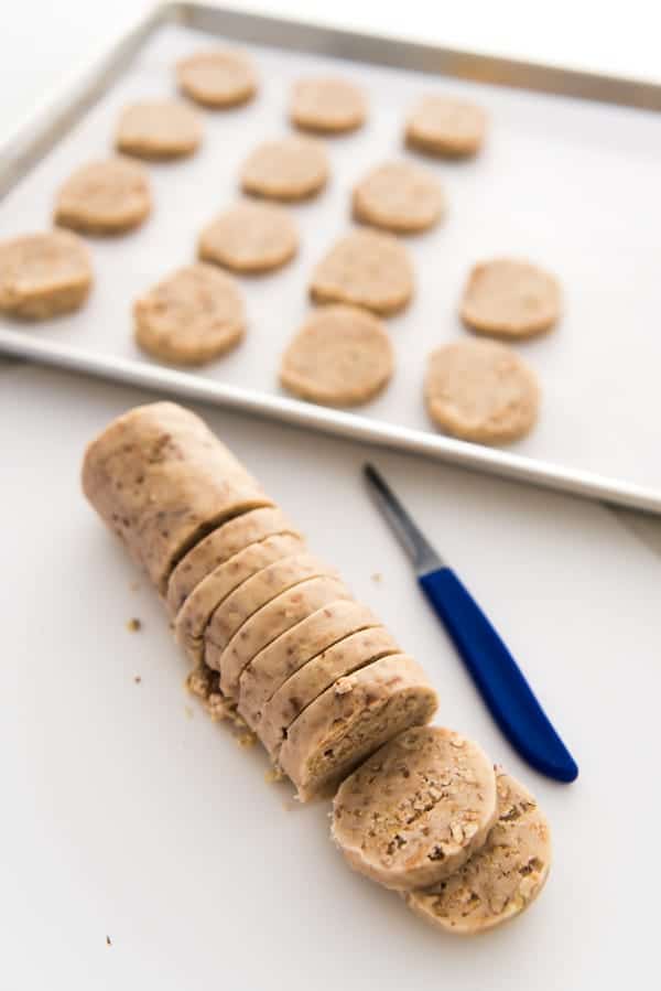 Toffee Pecan Shortbread dough rolled into a chilled log and sliced into individual cookies before baking.