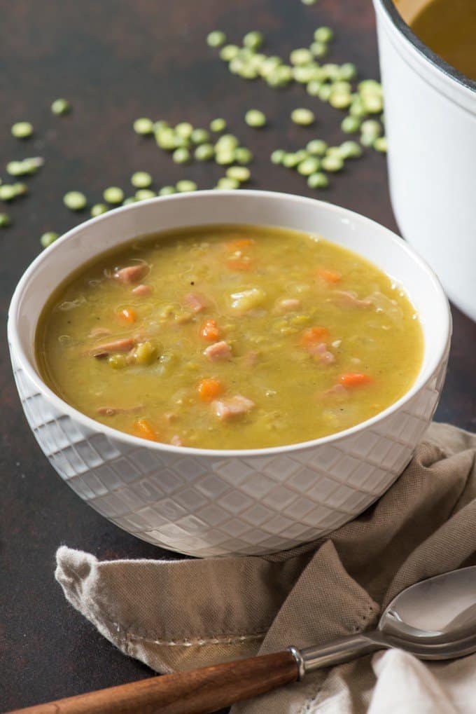 A white bowl of classic split pea soup made with ham and dried split peas.