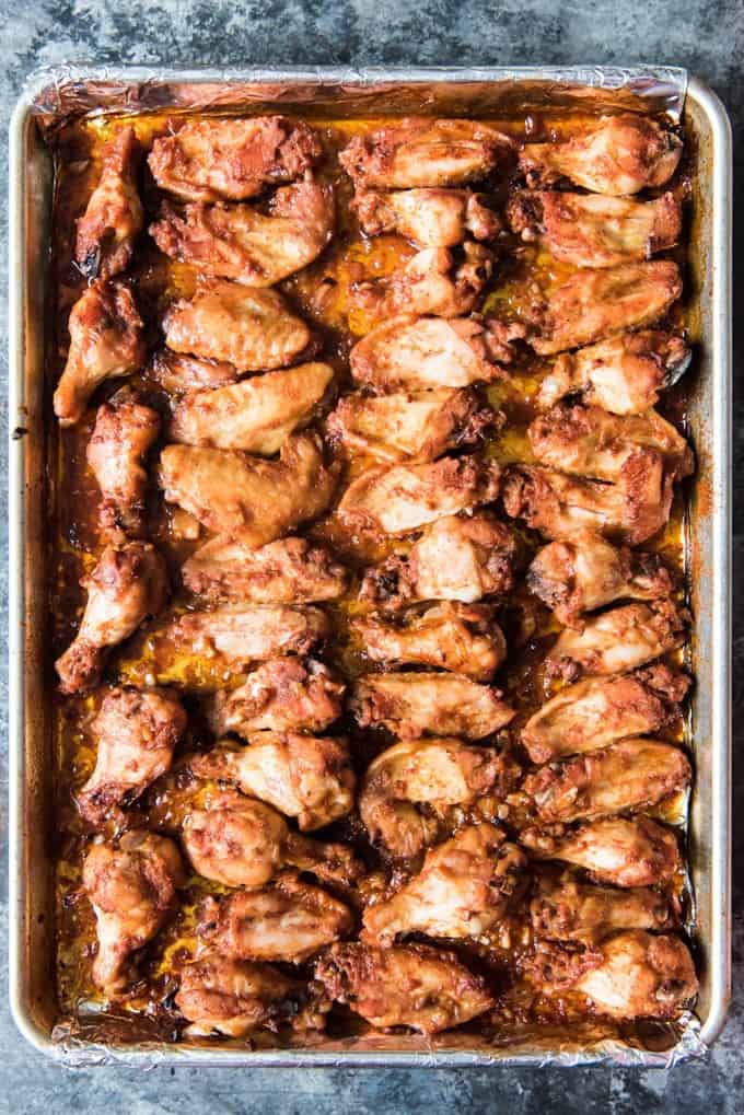 A sheet pan full of Oven Baked Korean BBQ Chicken Wings that are sweet, savory & spicy, thanks to a Korean red chile pepper paste called gochujang that adds fantastic flavor to this Asian-inspired Korean barbecue sauce.
