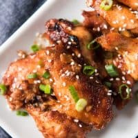 a close aerial shot of baked korean wings on a white plate