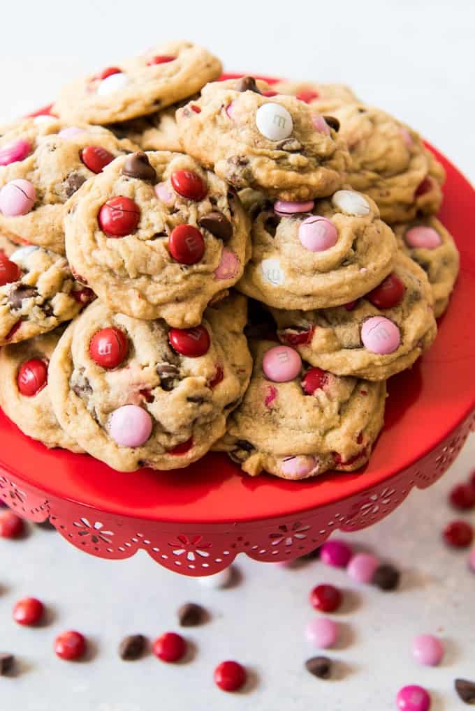 Valentine's Day M&M cookies piled on a red cake stand.