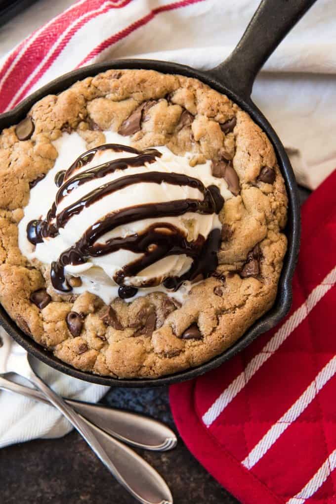 a skillet cookie topped with vanilla ice cream and chocolate sauce