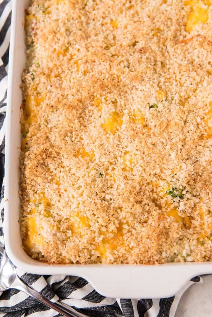 a close aerial view of the corner of a white baking dish filled with chicken broccoli rice casserole