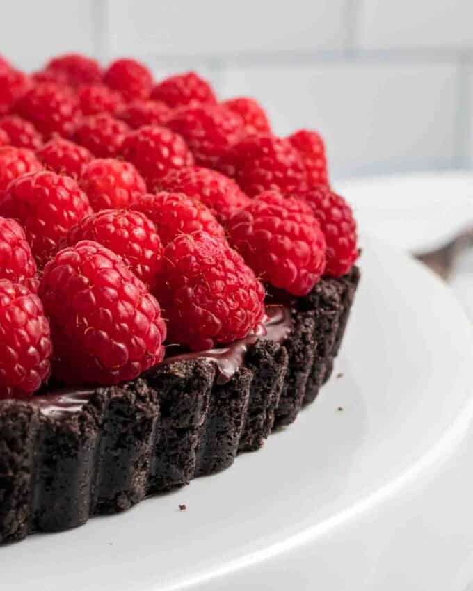 A side angle view of a raspberry chocolate tart.