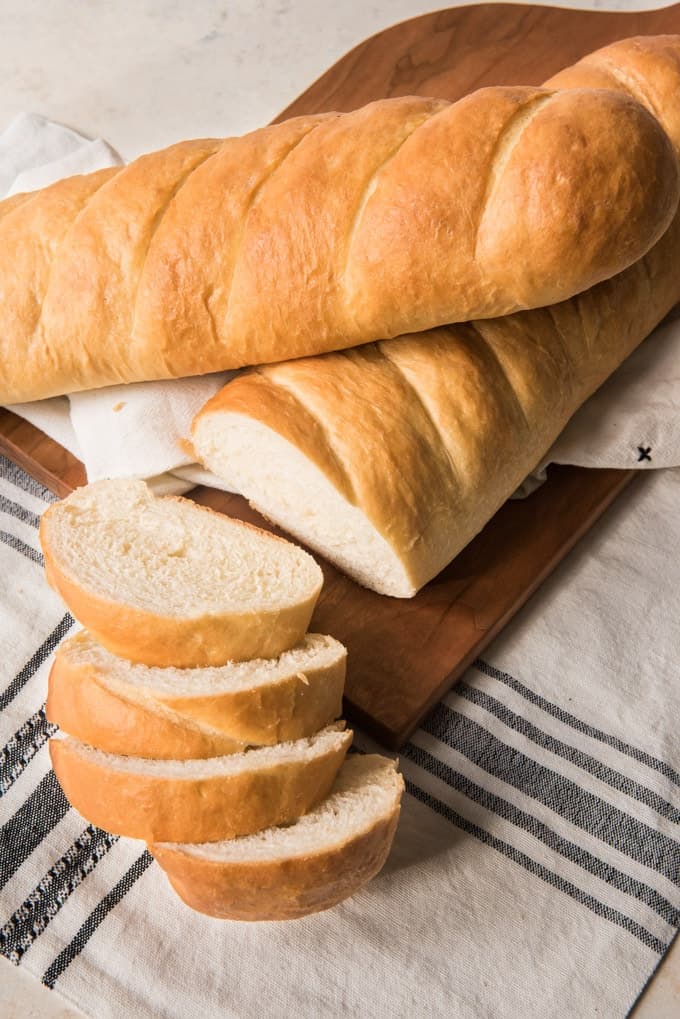 An image of two loaves of french bread, one of them sliced.