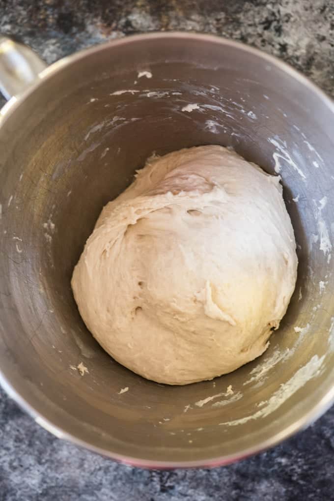A ball of yeast dough in a silver bowl ready for it's first rise.