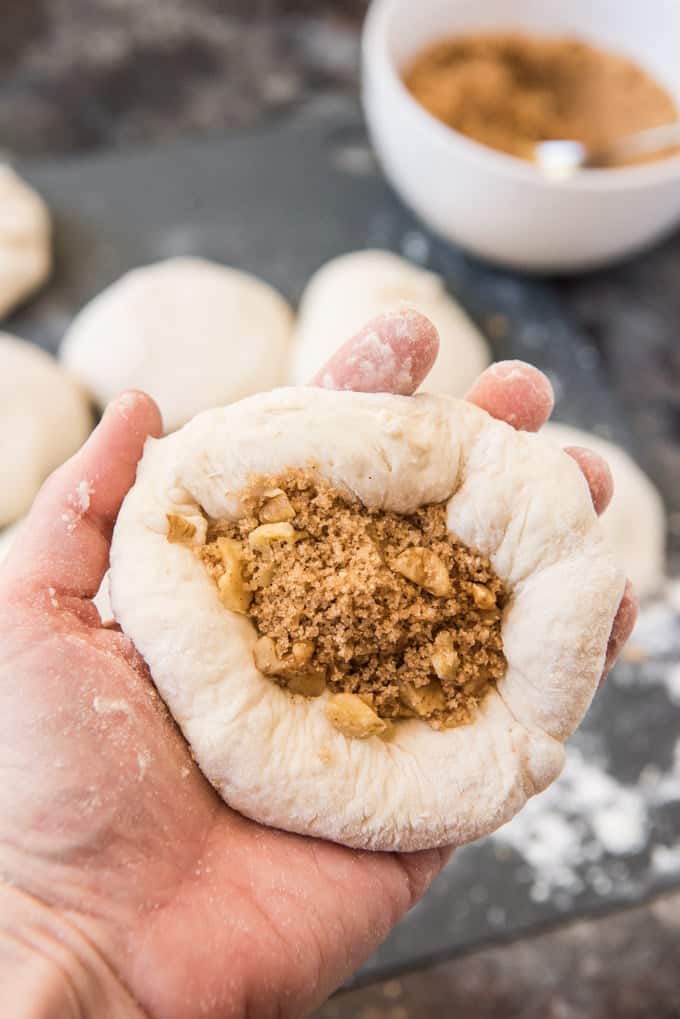 A ball of dough for korean sweet pancakes, flattened into a small disc and filled with brown sugar, cinnamon and walnuts.