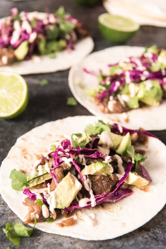 open faced bulgogi tacos with avocado, red cabbage and other ingredients