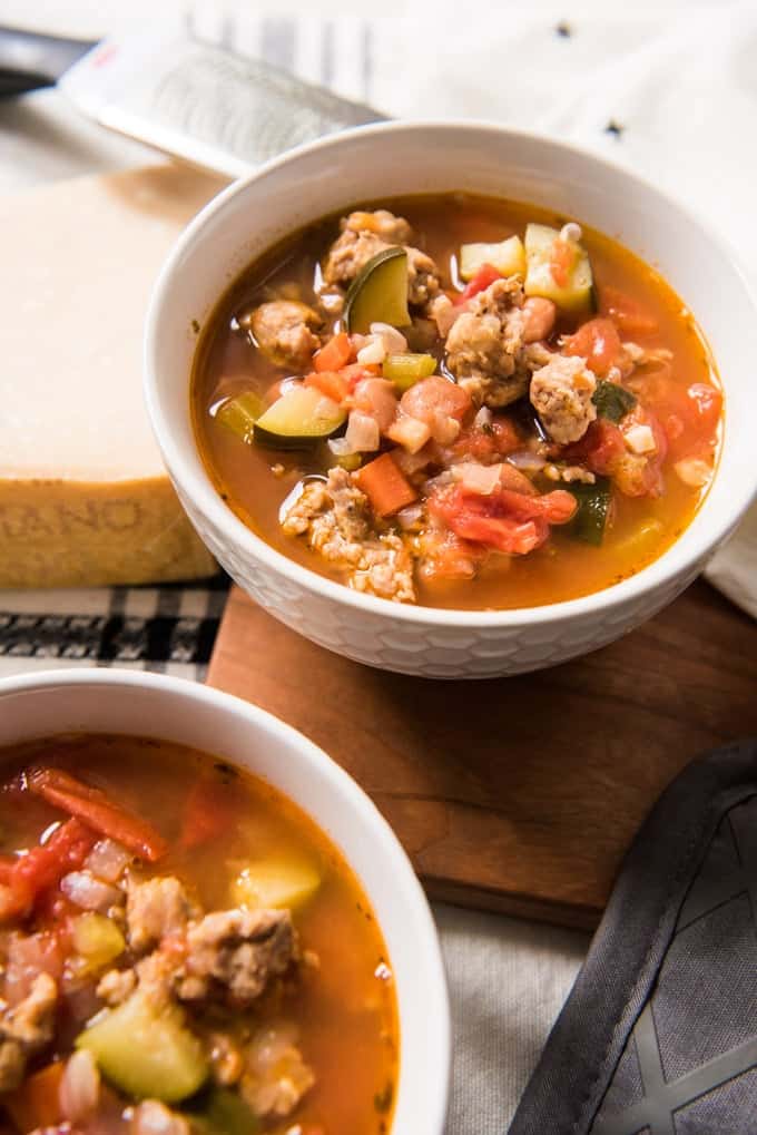 two white bowls of minestrone soup